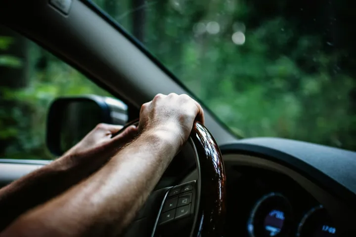Condutor com as mãos ao volante durante uma viagem