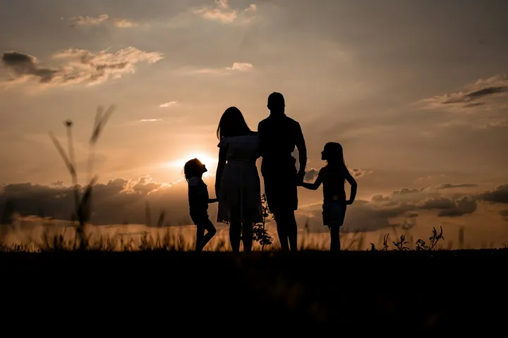 Família em silhueta observando o pôr do sol